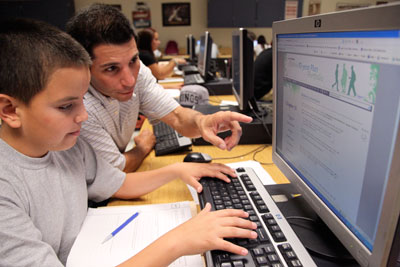 Student and teacher working on computer